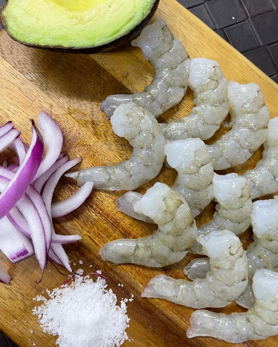 Camarones frescos en tabla con limón y cebolla